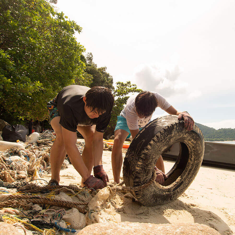 Two men cleaning up beach.