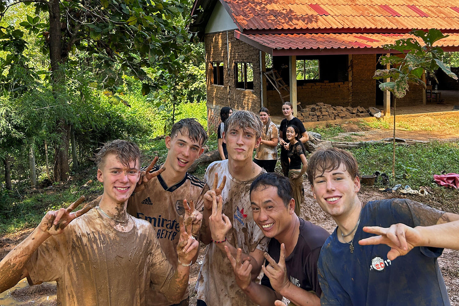 People posing for a picture in the mud.