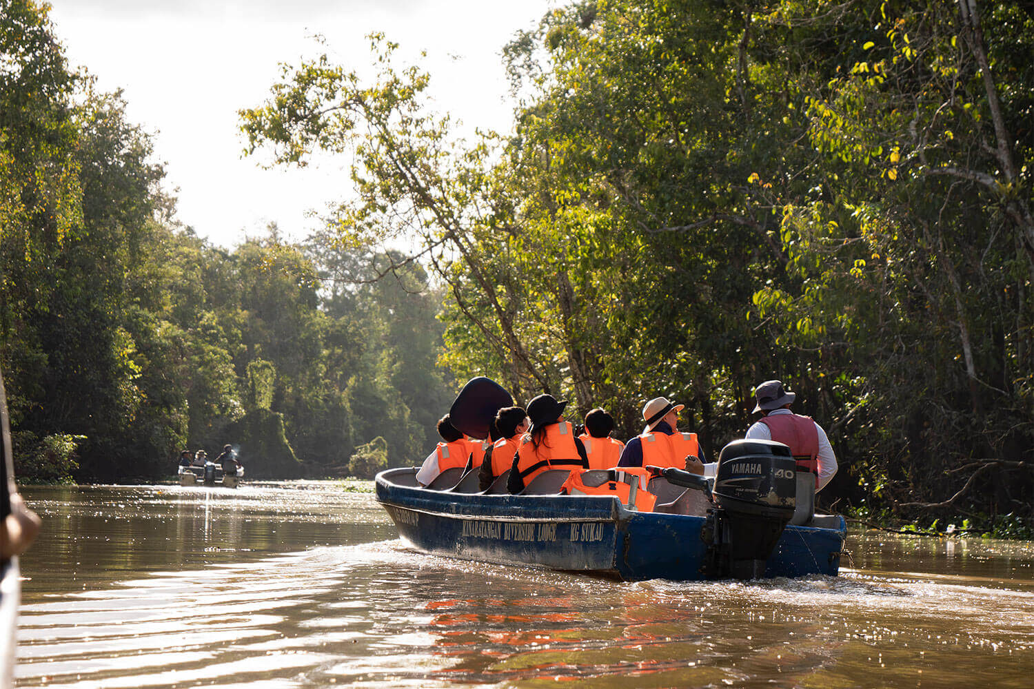 A group of people on a boat in the water.