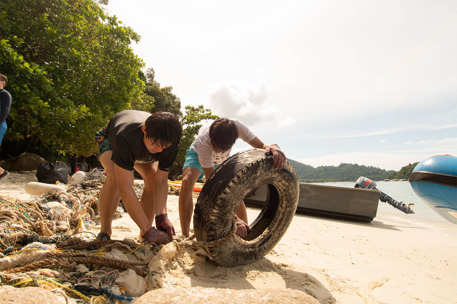 A group of people cleaning up trash on the beach.