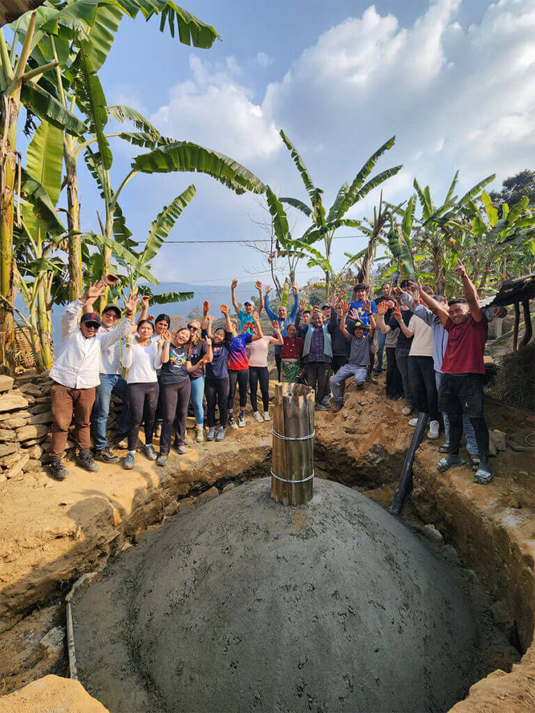 A group of people standing around a cement well.