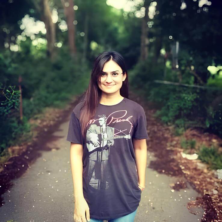 A woman wearing a t - shirt with a picture of a guitar player.